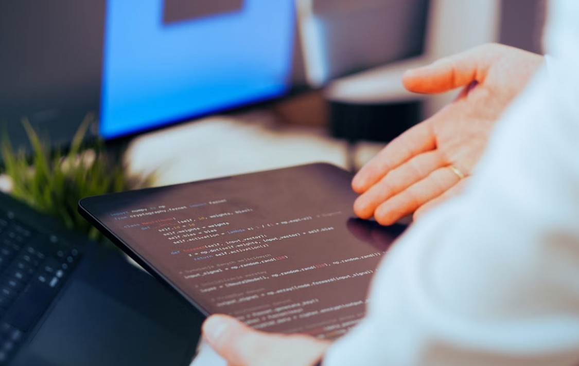 Developer reviewing the code on a tablet in office